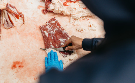 An Alta Vista Meat Co. employee trims steak.