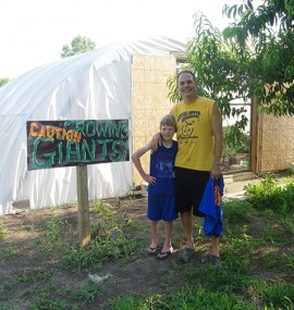 Jacob Marintzer and his son outside of the giant pumpkin greenhouse